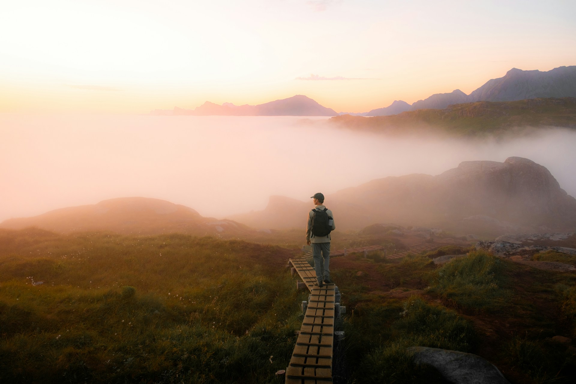 A walker on a boardwalk above the cloud at first light